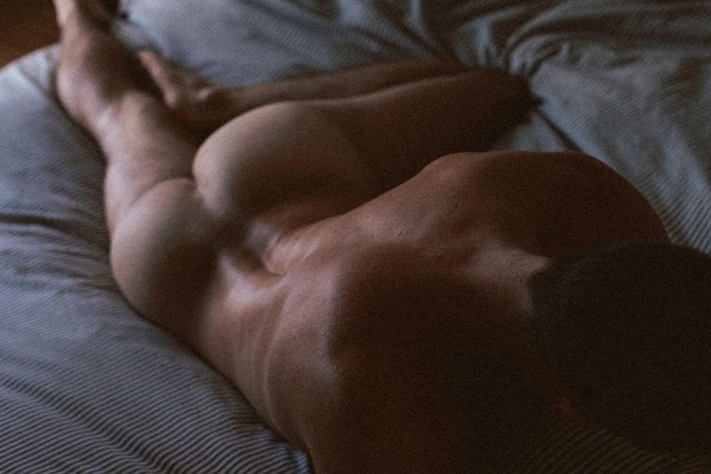 Nu masculin dos sur lit — boudoir intérieur lumière naturelle Belle Tronche Boudoir
